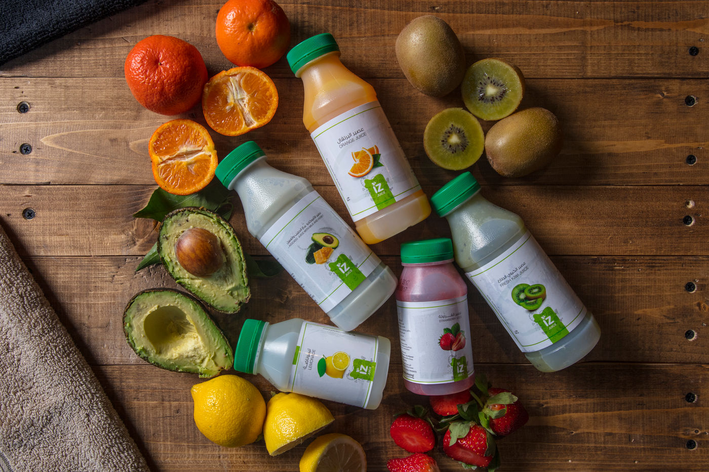 IZ Juice bottles arranged with fresh fruit on wood